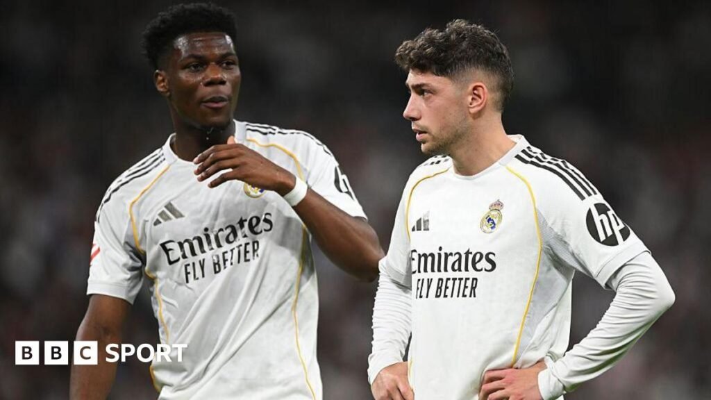 Real Madrid's Aurelien Tchouameni and Federico Valverde stand next to each other in a match, wearing the club's white kit